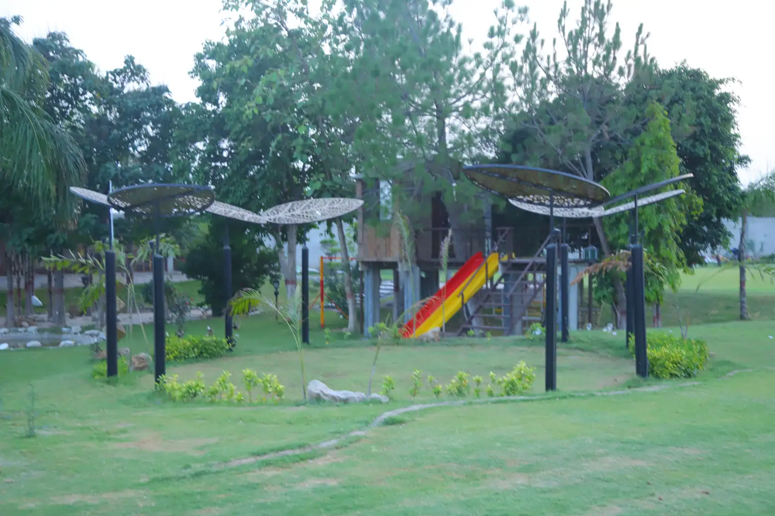 Kids play corner with treehouse, slide and shaded design elements
