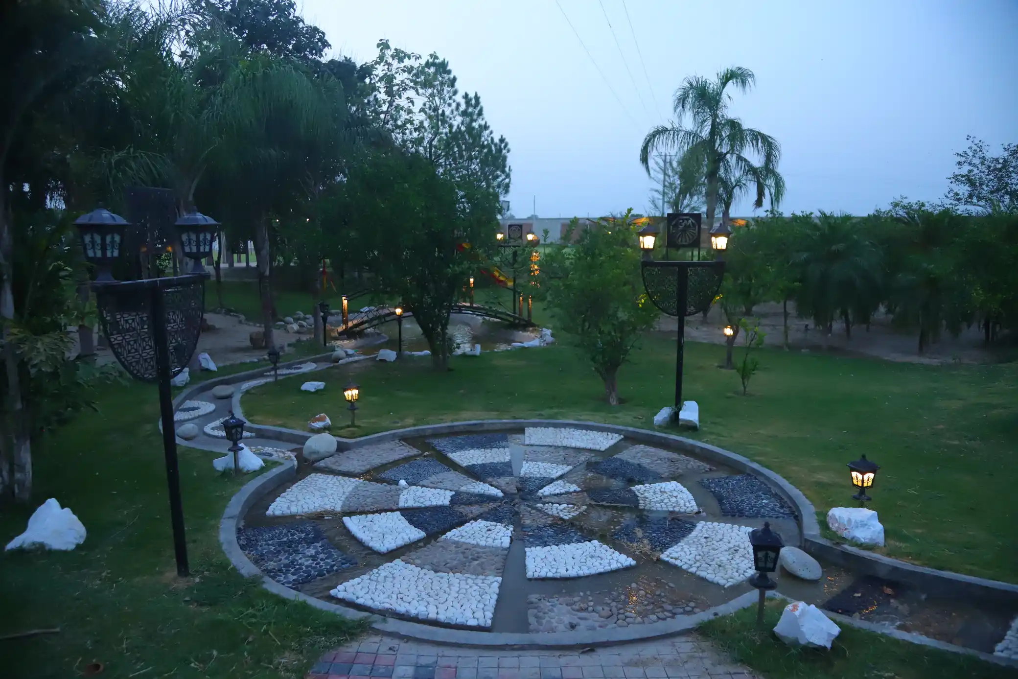 Evening couple shoot lawn with lantern feature and illuminated bridge