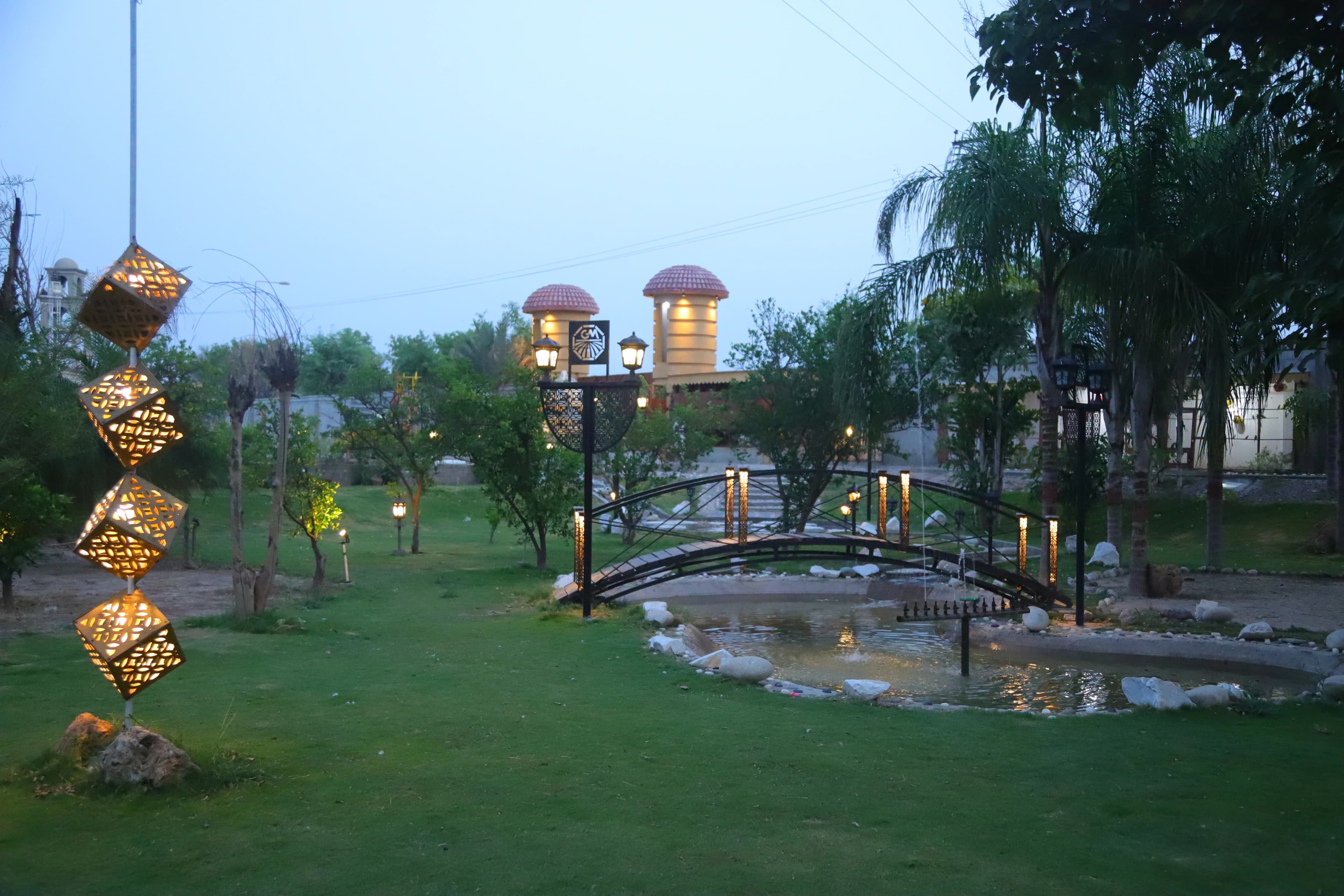 Bridge and pond area viewed through landscaped plants at Green Meadows Farm