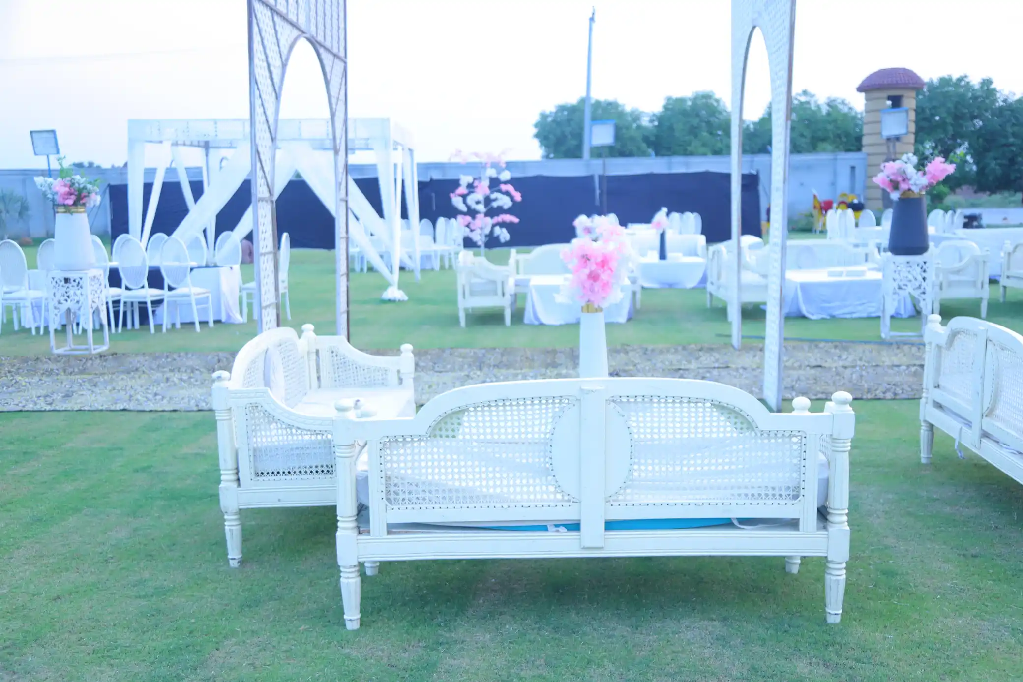 Bright lawn setup with white furniture and floral decor