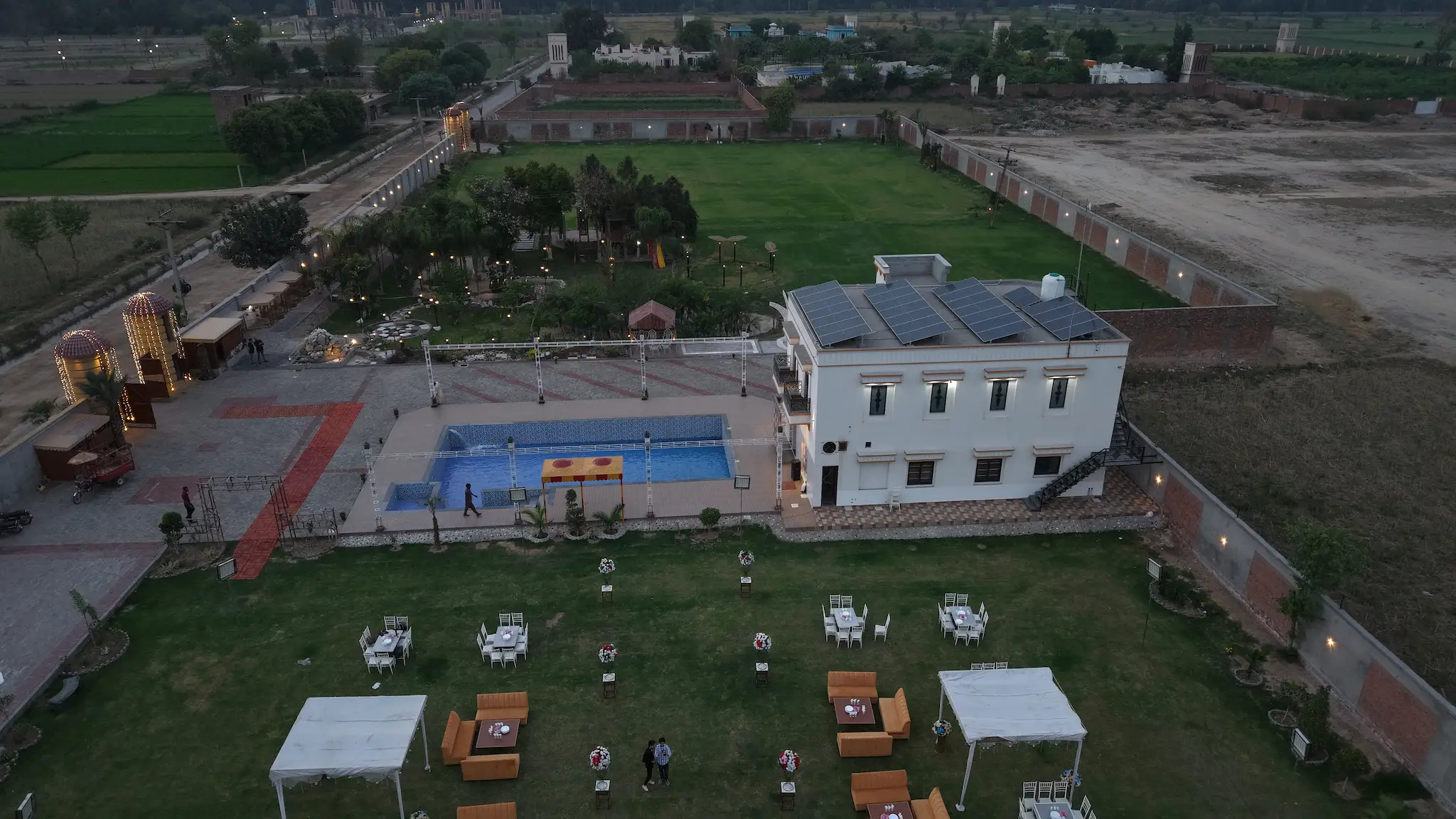 Pool side area in the evening with open lawn space around it